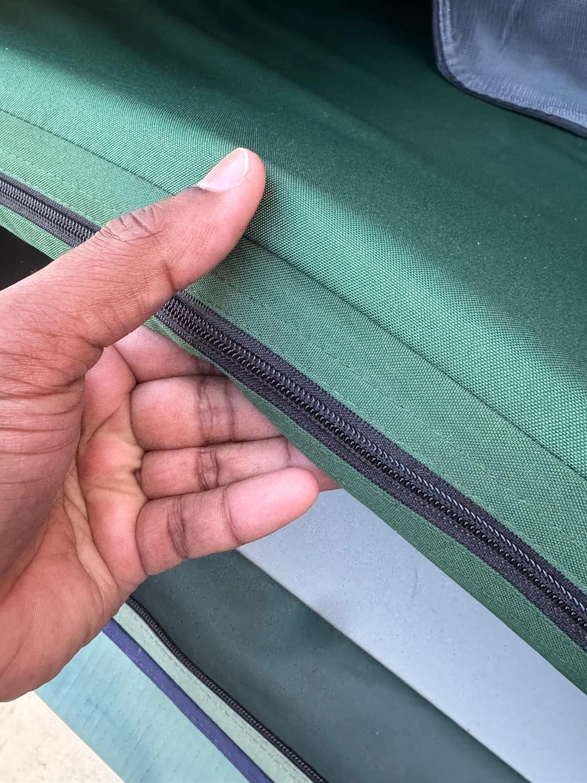 Hand showing the thickness of the Thule Tepui Explorer Kukenam 3's built-in foam mattress